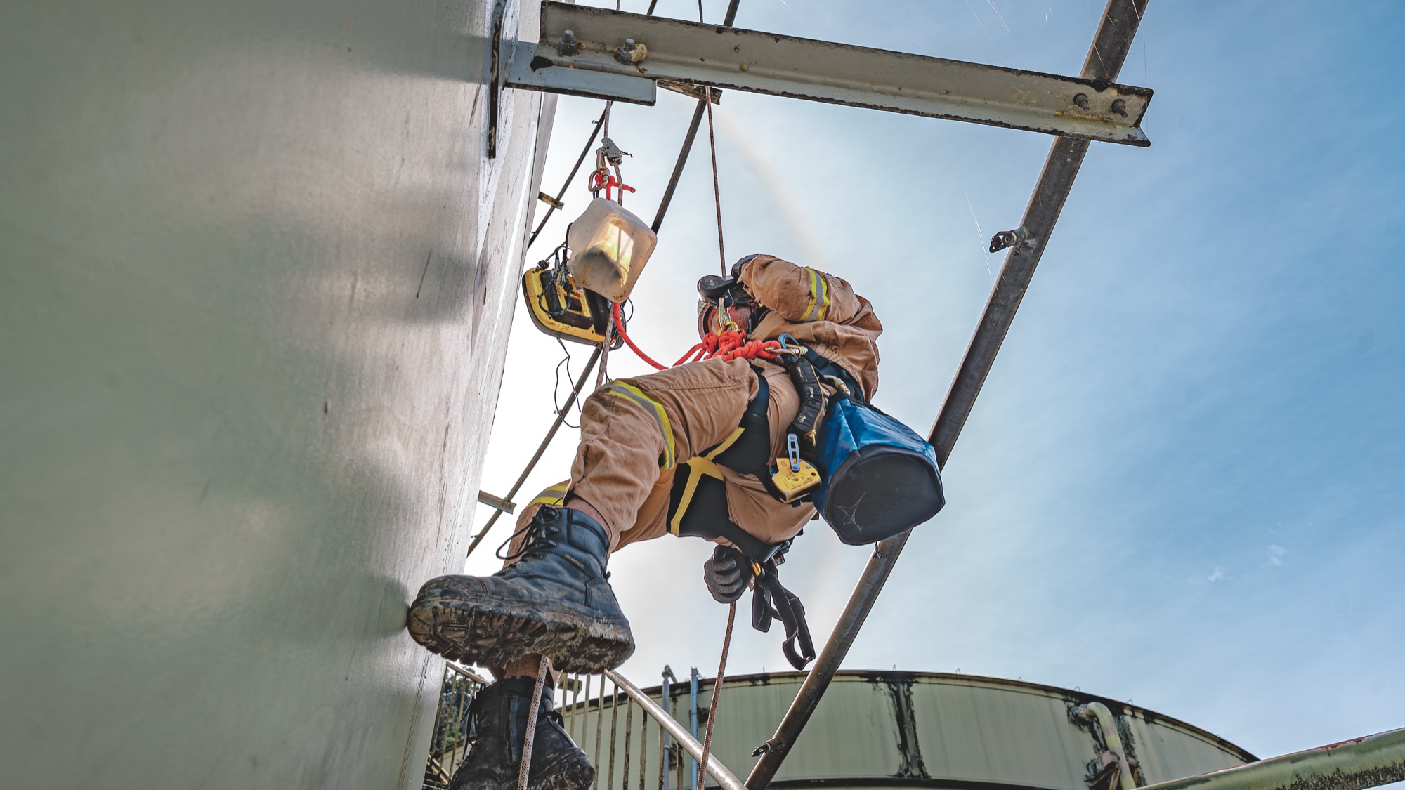 Rope-access technician inspecting a structural member at height