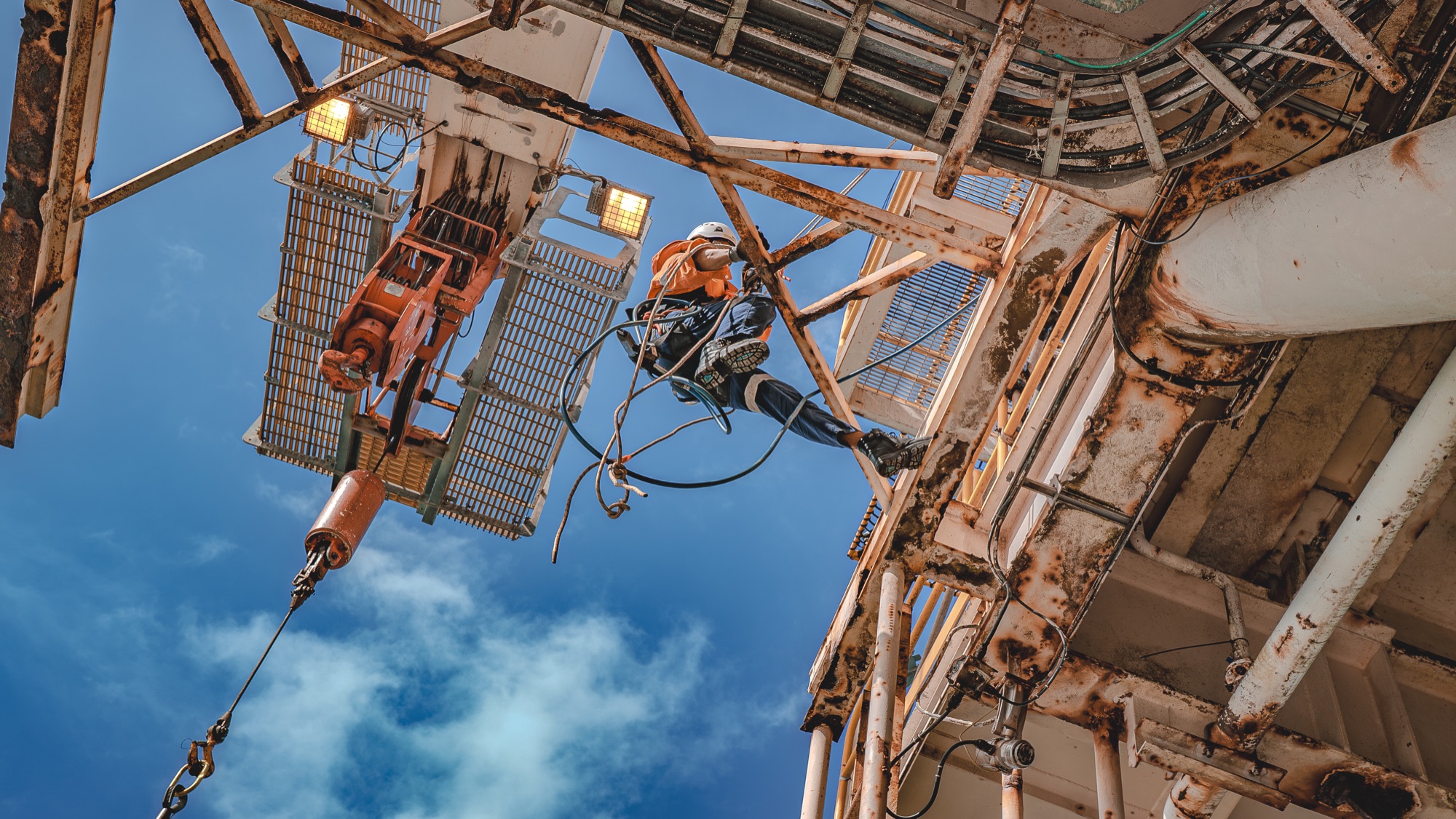 Rope-access technician working on a tall offshore structure